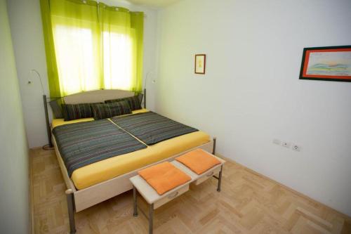 a small bedroom with a bed and a chair at Apartment Andrea in Trebinje