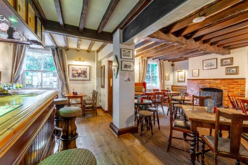 un restaurante con mesas y sillas y un bar en The Forest Lodge, en Edwinstowe