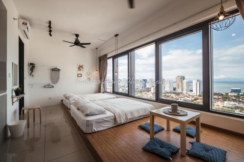 una camera da letto con un letto, un tavolo e grandi finestre di Xandra's 218 Macalister Suite a George Town