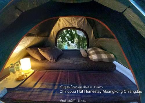 - un lit à baldaquin dans une tente dans l'établissement Chinopuu Hut Homestay Muangkong ชิโนปู ฮัท โฮมสเตย์ เมืองคอง เชียงดาว, à Mueang Khong