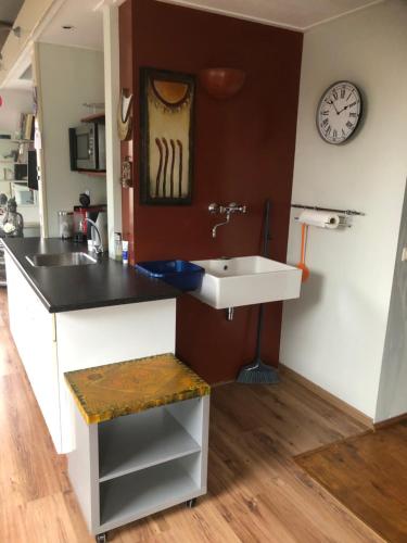 a kitchen with a sink and a clock on the wall at B & B Nomad in 't Zand