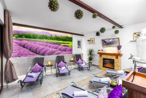 a living room with purple chairs and a fireplace at Hilson Jasna - Garden resort in Liptovský Mikuláš