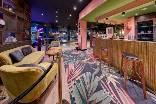 a bar with a couch and chairs in a restaurant at Hit the Sky in Sankt Christoph am Arlberg