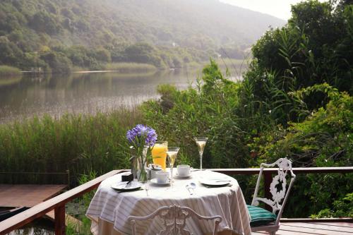 a table sitting on a deck with a view of a lake at Moontide Riverside Lodge in Wilderness