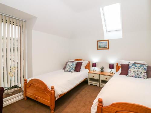 a bedroom with two beds and a window at The Bothy in Stonehaven
