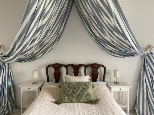 - une chambre dotée d'un lit avec des rideaux bleus dans l'établissement Château de Mazelières, à Espiens