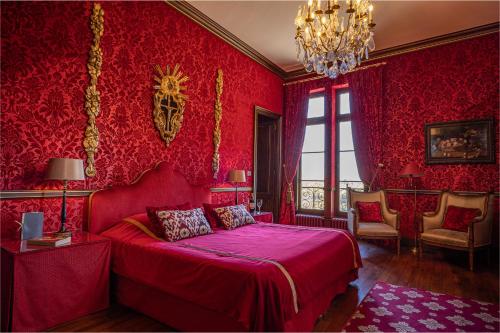 a bed room with a red bedspread and red pillows at Château Pape Clément in Pessac
