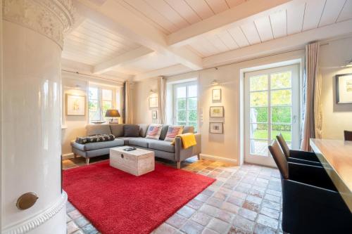 a living room with a couch and a red rug at Auster Hues in Midlum