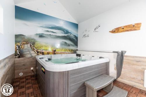 ein Badezimmer mit einer Badewanne und einem Wandgemälde in der Unterkunft Aux 2 Puys - Gîte "Le Lemptégy" in Saint-Priest-des-Champs