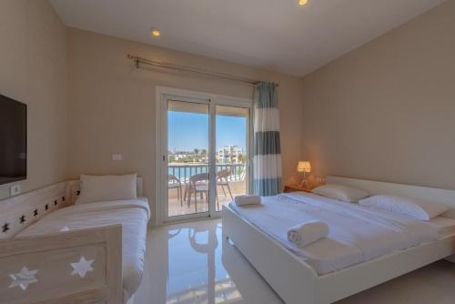 2 Betten in einem Schlafzimmer mit Balkon in der Unterkunft Joubal 3BR Villa Private Pool next to Marina in Hurghada