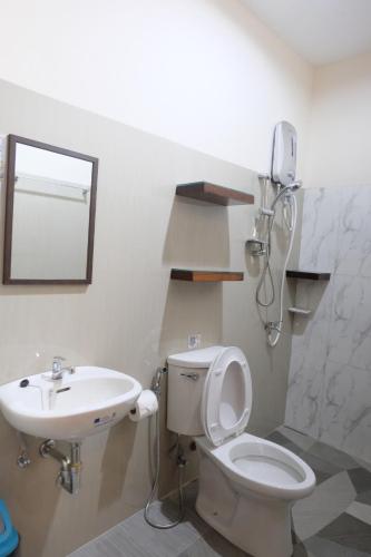 a bathroom with a toilet and a sink at MANANQUIL TRAVEL LODGE in El Nido