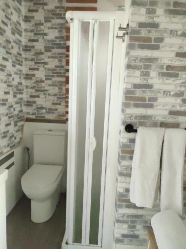 a bathroom with a toilet and a stone wall at SALTILLO ALTO WHITE STUDIO in Torremolinos