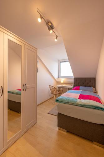 a attic bedroom with a bed and a window at Ferienwohnung Altötting in Unterneukirchen
