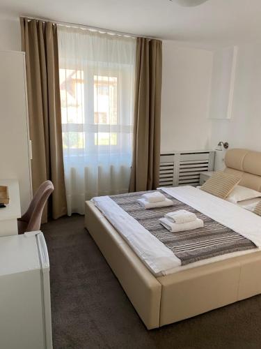 a bedroom with a large bed with towels on it at Guest House Piatra Craiului in Bran