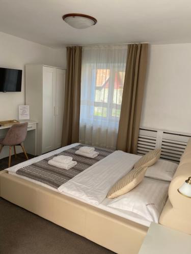 a large white bed in a room with a window at Guest House Piatra Craiului in Bran