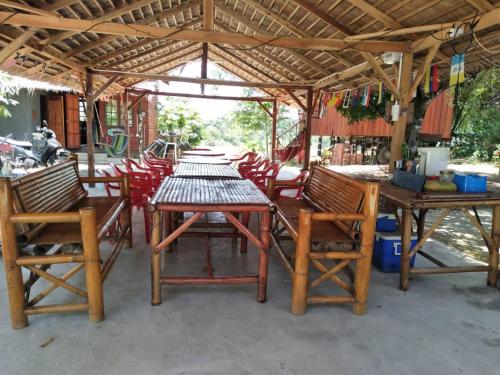 a group of tables and chairs under a pavilion at Betik Garden Home in Machang