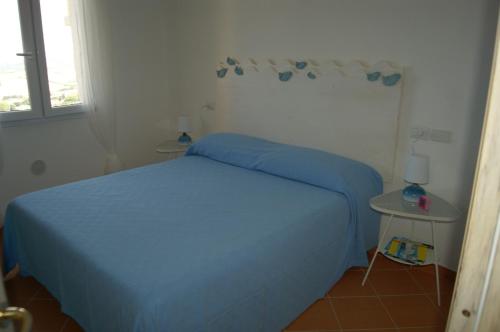 a bedroom with a bed with a blue blanket at Casa Elicriso in Castelsardo