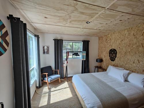 a bedroom with a bed and a chair and a window at Casa Harpers in White Beach