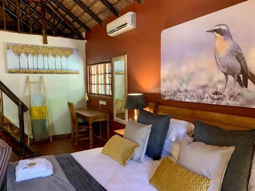 a bedroom with two beds and a bird painting on the wall at Morgenzon Estate in Pretoria