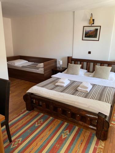 a bedroom with two beds and a chair at Guest House Piatra Craiului in Bran