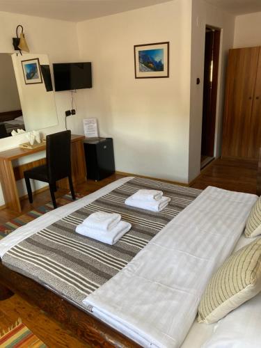 a large bed with two towels on top of it at Guest House Piatra Craiului in Bran