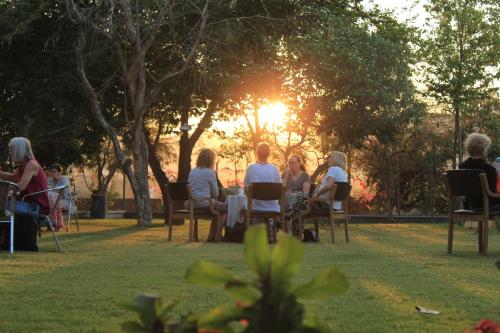 a group of people sitting in chairs in a park at PushkarOrganic - Lux farm resort with pool in Pushkar