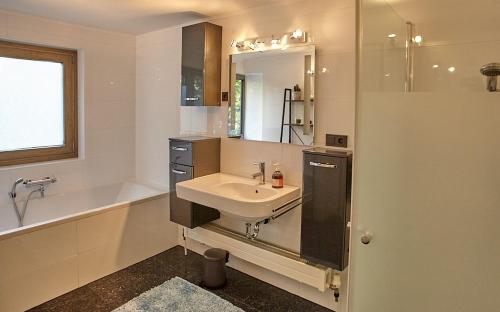 a bathroom with a sink and a bath tub and a sink at Keramikhaus Gmunden in Gmunden