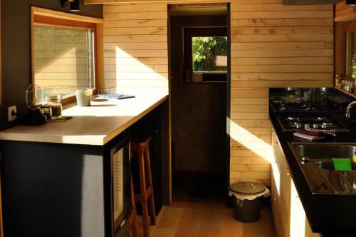 a kitchen with a counter top and a stove at Tiny House Célestine By Ernesst in Overijse