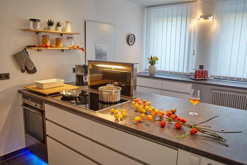 a kitchen with a counter with tomatoes and a glass of wine at Keramikhaus Gmunden in Gmunden