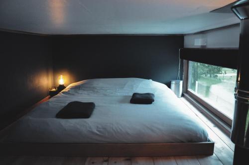 a bedroom with a large bed with two pillows on it at Tiny House Célestine By Ernesst in Overijse