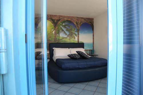 Sofá azul en una habitación con cama en Hotel Darsena, en Pozzuoli