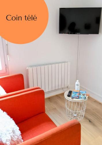 un salon avec une chaise rouge et une télé dans l'établissement Appartement Hypercentre Calme proche Centre des Congres, à Angers