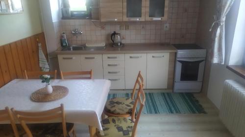 una piccola cucina con tavolo, sedie e lavandino di Katka a Martin samostatný apartmán s vlastným vchodom a Liptovský Mikuláš