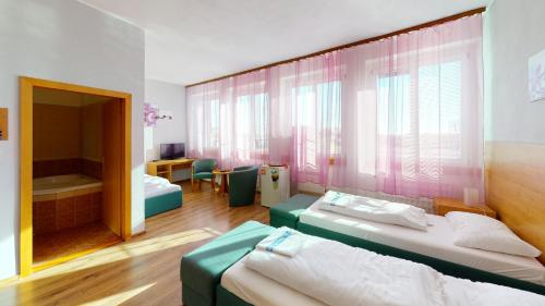 a hotel room with two beds and a bathroom at Hotel Hubert Nové Zámky in Nové Zámky