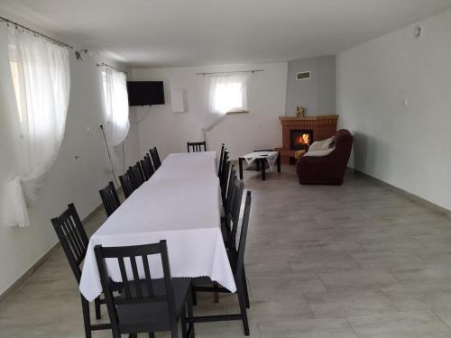 a dining room with a table and chairs and a fireplace at Gospodarstwo Agroturystyczne w Borszycach in Wola Pękoszewska