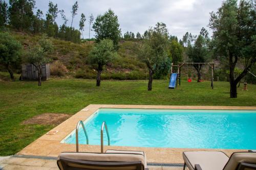 a swimming pool in a yard with a playground at Boavista Country Houses no 93 in Vila Nune