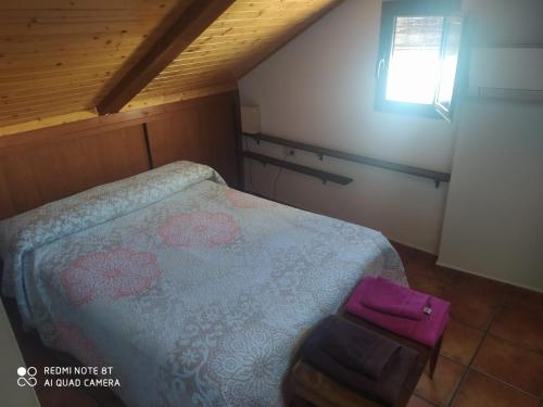 - une petite chambre avec un lit et un sac pourpre dans l'établissement Santa Lucía, à Cuenca