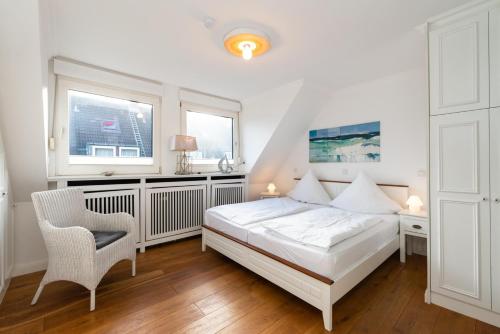 1 dormitorio con 1 cama, 1 silla y 2 ventanas en Meeresstern en Westerland