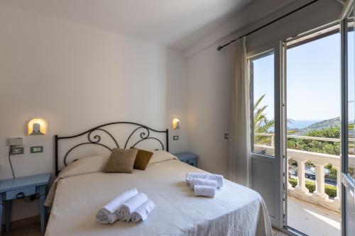 a bedroom with a bed and a large window at Hotel Castello Monticello in Giglio Porto