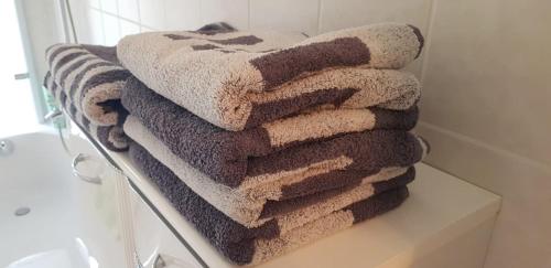 a pile of towels sitting on a towel rack in a bathroom at An den Elbwiesen in Dresden