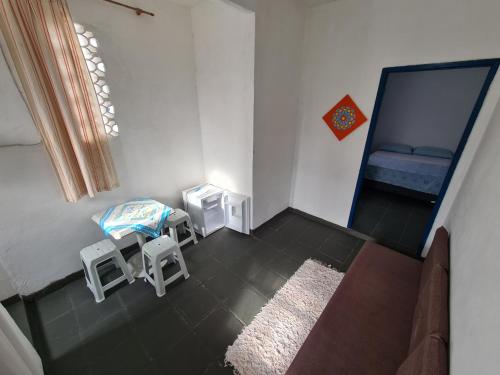 a room with a couch and a chair and a mirror at Santorini Flats in Arraial do Cabo