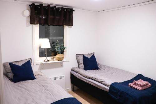 1 dormitorio con 2 camas y ventana en Frost Longstay Egnahemsvägen en Kiruna