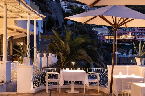 a patio area with tables, chairs and umbrellas at Miramare Sea Resort & Spa in Ischia