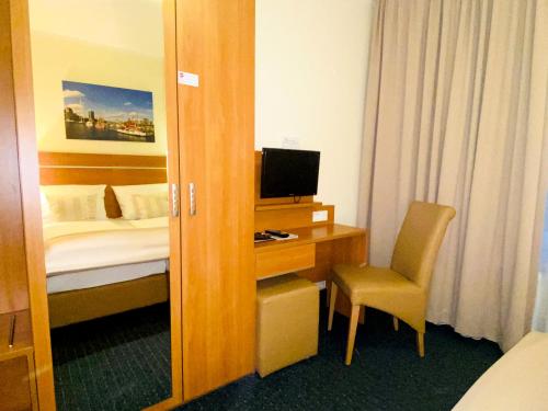 a hotel room with a bed and a desk with a computer at Hotel Hansehof in Hamburg