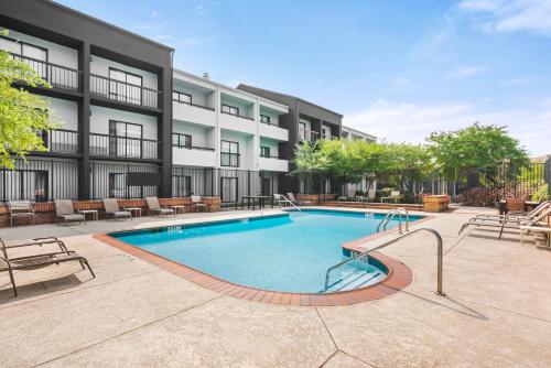 a swimming pool in front of a building at Super 8 by Wyndham Dallas Love Field Airport in Dallas