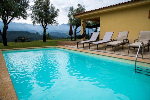 a swimming pool with chairs and a table at Boavista Country Houses no 93 in Vila Nune