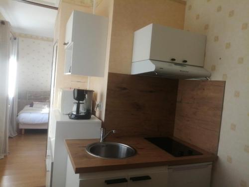 a small kitchen with a sink and white cabinets at Maison d'hôtes Les Vallées in Saint-Quentin-sur-le-Homme