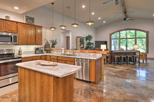 a large kitchen with wooden cabinets and a kitchen island at Riverfront Heaven on the White with Covered Patio! in Norfork