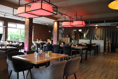 ein Restaurant mit Holztischen und -stühlen und rosa Lichtern in der Unterkunft Hotel Mintarder Wasserbahnhof in Mülheim an der Ruhr