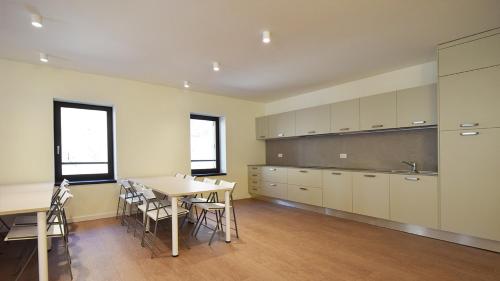 a large kitchen with a table and a table and chairs at La Meira Sermig Casa Ferie in Crissolo